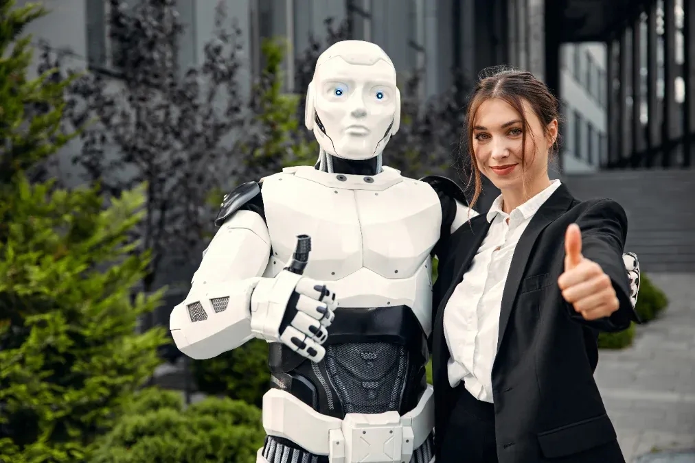 A humanoid robot and a researcher giving a thumbs-up